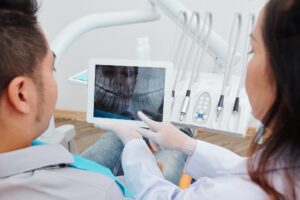 Orthodontist showing jaw x-ray to patient